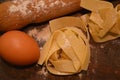 Tipical italian pasta pappardelle freh food homemade with eggs on table and kitchen utensils