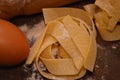 Tipical italian pasta pappardelle freh food homemade with eggs on table and kitchen utensils