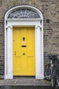 A tipical yellow wooden door in Dublin of a victorian house with bycicle