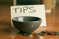 Tipping bowl in coffee shop with coins Royalty Free Stock Photo