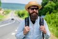 Tips of experienced backpacker. Man bearded hipster backpacker at edge of highway. Pick me up. Backpacker waiting for Royalty Free Stock Photo