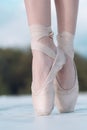 On the tips of the toes. Female feet in pointe shoes. Pointe shoes worn by ballet dancer. Ballerina shoes. Legs in white Royalty Free Stock Photo