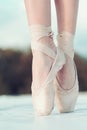 On the tips of the toes. Female feet in pointe shoes. Pointe shoes worn by ballet dancer. Ballerina shoes. Legs in white Royalty Free Stock Photo