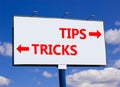 Tips and tricks symbol. Concept word Tips and tricks on beautiful billboard with two arrows. Beautiful blue sky with clouds Royalty Free Stock Photo