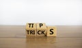 Tips and tricks symbol. Tured cubes and changed the word `tricks` to `tips`. Beautiful wooden table, white background. Busines