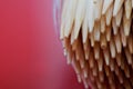 The tips of wooden bamboo toothpicks in an oval container on a red background. Super Macro. Shallow depth of field. Daylight Royalty Free Stock Photo