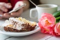 Tiramisu cake, female hands holding smartphone and cup of coffee and pink tulips Royalty Free Stock Photo