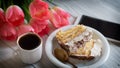 Tiramisu cake, pink tulips and cup of coffee on a white wooden table Royalty Free Stock Photo