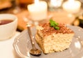 Tiramisu by candlelight, romantic date in Italy, tiramisu dessert on a porcelain plate