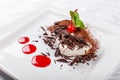 Tiramisu. Classical Dessert with cocoa and chocolate on white square plate. Garnished with Cherry and Mint. Sweet