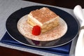 Tiramisu with sliced strawberry on a blue plate Royalty Free Stock Photo