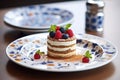 tiramisu topped with berries on a ceramic plate