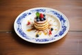 tiramisu topped with berries on a ceramic plate