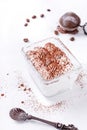 Tiramisu topped with cocoa powder in glass portion bowl