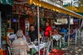 A beautiful and cozy cafe with people sitting at tables and waiters in the capital of Albania - Tirana. Albanian cuisine