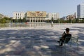 Tirana, Albania, July 8 2019: A young Albanian is sitting in the shadows at Skanderbeg Square in Tirana