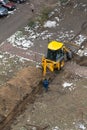 JCB excavator digs a trench for laying a sewer pipe. Worker of the water supply and Royalty Free Stock Photo