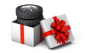 Tire as a gift. A set of four tires in a gift box tied with a red gift ribbon with a bow. isolated on white background