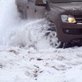 Tire on car wheel close-up skidding on a snowy winter road