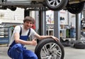 Tire change in a car workshop by mechanic - portrait og smiling Royalty Free Stock Photo