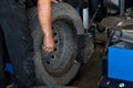 Tire change closeup, Mechanic is changing car tire engineer balancing car wheel on balancer in workshop Royalty Free Stock Photo