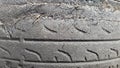 A tire that is damaged after prolonged use. A worn-out and torn car tire in a junkyard