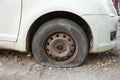 Tire leak, close up wheel of old white vintage car. Car wheel flat tire on the road. Deflated the tyre of an old car next to a Royalty Free Stock Photo