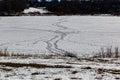 Tire marks and traffic tracks on frozen lake surface in winter. Royalty Free Stock Photo