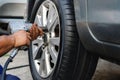 Tire Replacement concept. Mechanic Using Electric Screwdriver Wrench for Wheel Nuts in Garage. Car Maintenance Royalty Free Stock Photo