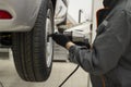 Tire service. Mechanic attaches the wheel to the car