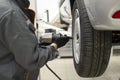 Tire service. Mechanic attaches the wheel to the car