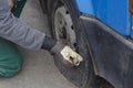 Tire service, car service concept. Car mechanic manually unscrews the bolts on the wheel