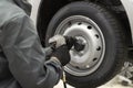 Tire service. Mechanic attaches the wheel to the car
