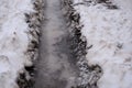 Tire track in the melting snow on the road. Royalty Free Stock Photo