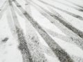 Tire tracks and footprints in fresh snow create a pattern on a winter landscape, showcasing the contrast between white s Royalty Free Stock Photo