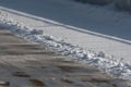 Tire tracks on melting snow. Warming in winter, changing road conditions Royalty Free Stock Photo