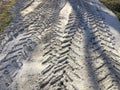 Tire tracks in sand close-up across sunlights. Road close-up Royalty Free Stock Photo