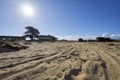 Tire tracks through the sand leading to deserted military base