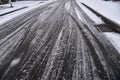 Tire tracks on a snowy road in the slush