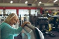 Tired active senior woman wiping sweat towel in fitness studio