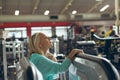 Tired active senior woman wiping sweat towel in fitness studio