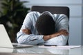 Tired african american businessman sleeping at workplace in office. Royalty Free Stock Photo