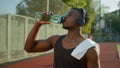 Tired African American sport man male muscular sportsman runner athlete drinking water sports bottle refresh body