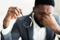 Tired african businessman taking his glasses off Royalty Free Stock Photo