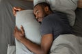 Tired African Male Lying Having Sleeplessness In Bedroom, High Angle