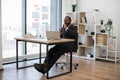 Tired african man sitting at office desk and yawning Royalty Free Stock Photo