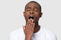 Tired african man yawning cover mouth with hand studio shot Royalty Free Stock Photo