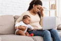 Tired African Mother With Crying Baby Using Laptop At Home Royalty Free Stock Photo