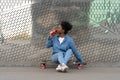 Tired afro american skateboarder girl refreshing after longboarding sit on skate drink soda beverage Royalty Free Stock Photo