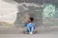 Tired afro american skateboarder girl refreshing after longboarding sit on skate drink soda beverage Royalty Free Stock Photo